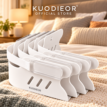 KUODIEOR® Grip™ white bed sheet holders, 4-pack, displayed on a beige knit blanket in a bedroom setting.